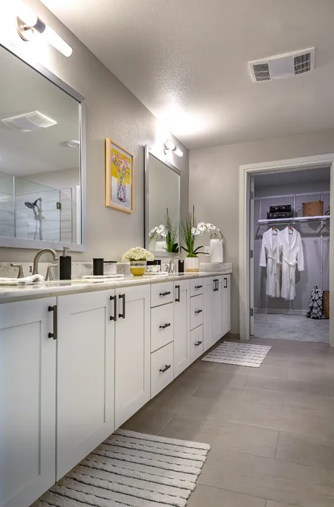Large bathroom with a dual vanity and a walk-in closet attached at the end